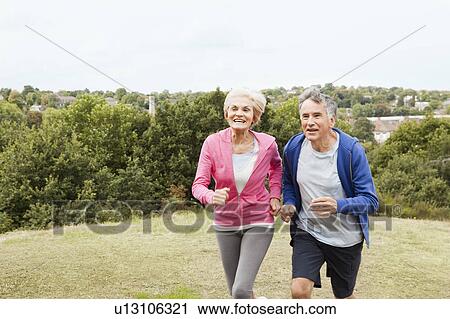 Mature couple running in park View Large Photo Image Stock Image - Mature couple running in park. Fotosearch