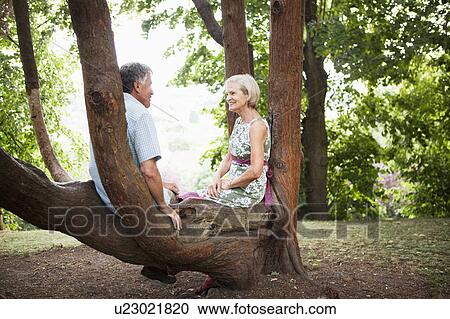 Mature couple sitting in tree, relaxing View Large Photo Image Stock Image - Mature couple sitting in tree, relaxing. Fotosearch