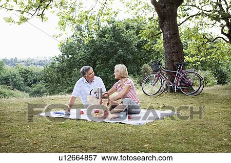 Mature couple unpacking picnic basket View Large Photo Image Stock Photo - Mature couple unpacking picnic basket. Fotosearch