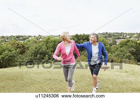 Stock Photograph - Mature man holding onto jogging partner. Fotosearch