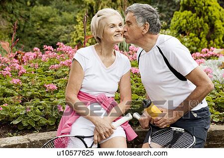 Stock Photography - Mature man kissing partner on cheek. Fotosearch