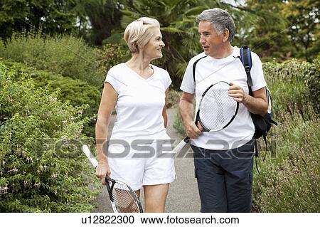 Mature tennisplayers walking and talking View Large Photo Image Stock Image - Mature tennisplayers walking and talking. Fotosearch