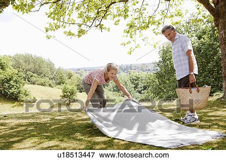 Mature woman spreading picnic blanket View Large Photo Image Stock Photo - Mature woman spreading picnic blanket. Fotosearch