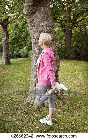 Mature woman stretching leg in park View Large Photo Image Stock Image - Mature woman stretching leg in park. Fotosearch