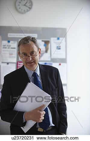 Stock Image - Medical Consultant holding paperwork. Fotosearch
