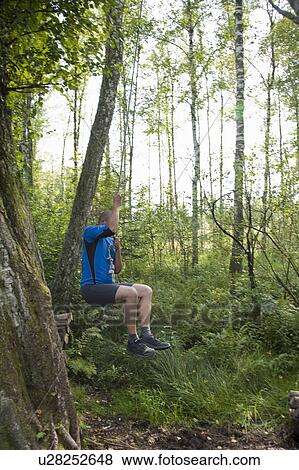 Stock Photo - Men swinging at a rope. Fotosearch