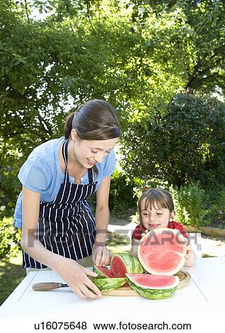 Mother and daughter prepare water melon View Large Photo Image Stock Photo - Mother and daughter prepare water melon. Fotosearch