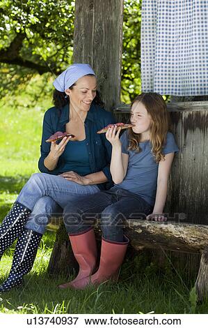 Mother and daughter resting on shed View Large Photo Image Stock Photo - Mother and daughter resting on shed. Fotosearch