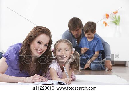 Mother and daughter with book on rug View Large Photo Image Stock Image - Mother and daughter with book on rug. Fotosearch