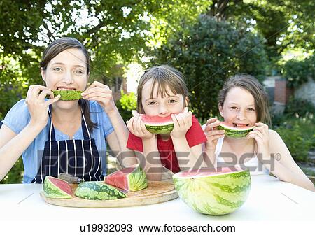Mother and daughters eat water melon View Large Photo Image Stock Image - Mother and daughters eat water melon. Fotosearch