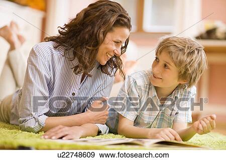 Stock Photo - Mother and son reading journals. Fotosearch
