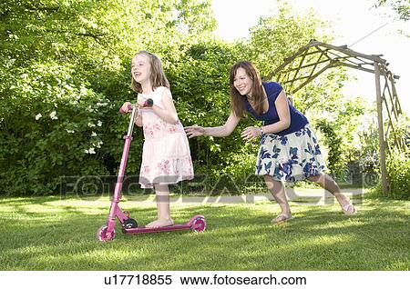 Mother chases daughter in garden View Large Photo Image Stock Photography - Mother chases daughter in garden. Fotosearch