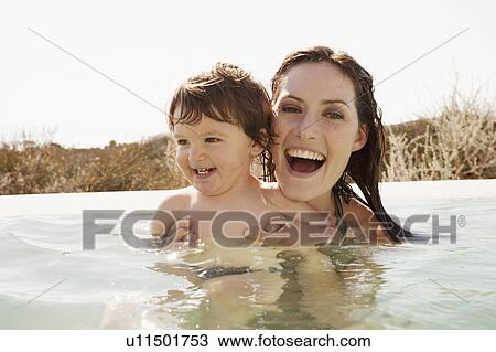 Stock Image - Mother with baby boy in swimming pool. Fotosearch