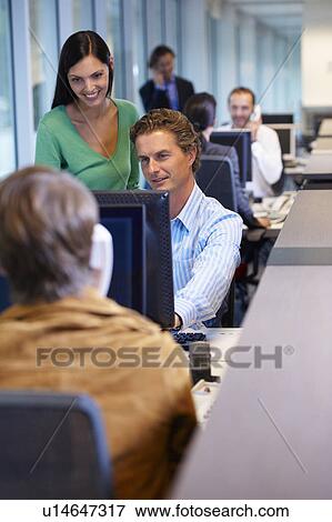 Office workers looking at a computer View Large Photo Image Stock Photo - Office workers looking at a computer. Fotosearch