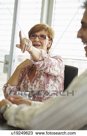 Stock Image - Older business woman in meeting. Fotosearch