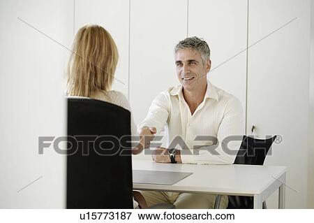 Stock Photo - Older man and woman shaking hands. Fotosearch