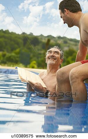 Older man reading news in swimming pool View Large Photo Image Stock Photography - Older man reading news in swimming pool. Fotosearch