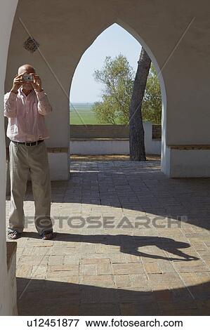 Older tourist man taking a snapshot View Large Photo Image Stock Photo - Older tourist man taking a snapshot. Fotosearch