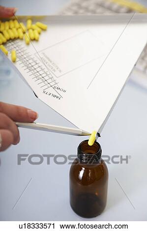 Stock Image - Pharmacist counting pills. Fotosearch