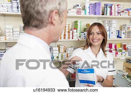 Pharmacist handing over prescription View Large Photo Image Stock Image - Pharmacist handing over prescription. Fotosearch