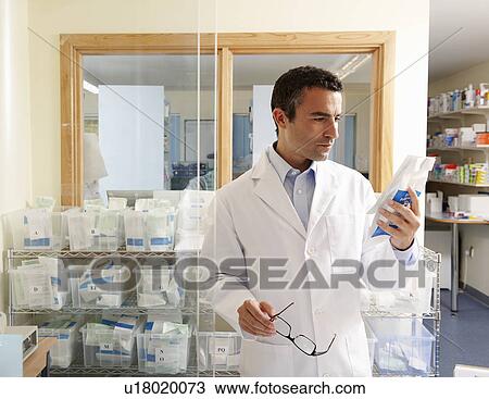 Pharmacist looking at packet View Large Photo Image Stock Image - Pharmacist looking at packet. Fotosearch