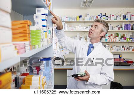Pharmacist looking at shelf of pills View Large Photo Image Stock Photography - Pharmacist looking at shelf of pills. Fotosearch