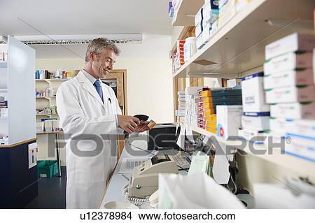 Pharmacist scanning pill box View Large Photo Image Picture - Pharmacist scanning pill box. Fotosearch