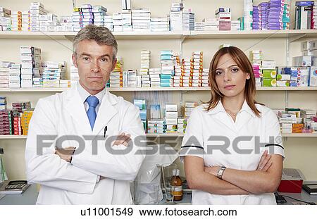 Stock Photo - Pharmacists by shelves of drugs. Fotosearch