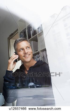 Phoning man looking out window View Large Photo Image Stock Photograph - Phoning man looking out window. Fotosearch