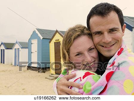 Stock Image - Portrait of happy couple on beach. Fotosearch