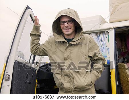 Stock Photo - Portrait of male camper in rain. Fotosearch