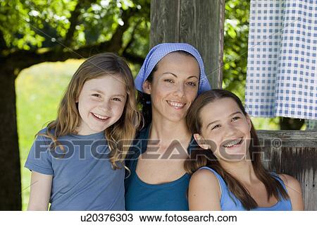 Stock Image - Portrait of mother and daughters, happy. Fotosearch