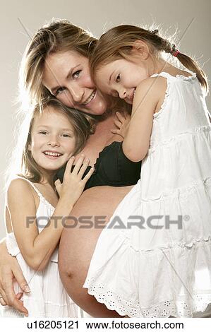Stock Image - Pregnant woman with her two daughters. Fotosearch