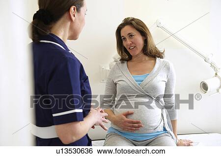 Stock Photograph - Pregnant woman with nurse in clinic. Fotosearch