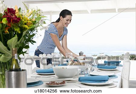 Stock Photograph - Preparing a table for a meal. Fotosearch