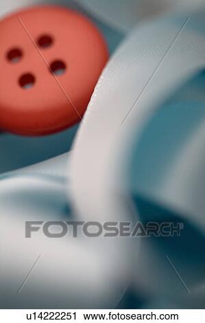 Stock Image - Red button with blue ribbon. Fotosearch