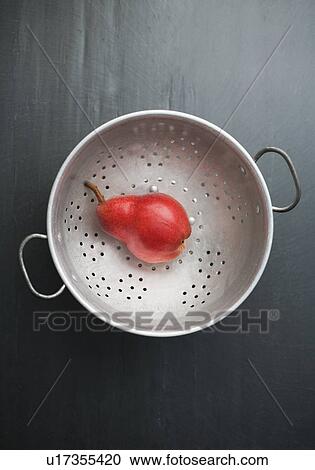 Stock Image - Red pear on a colander. Fotosearch