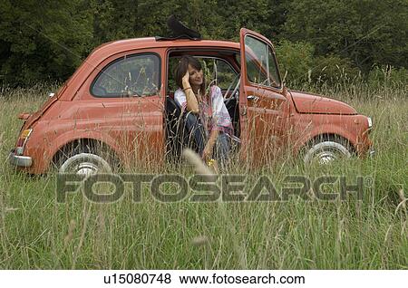 Relaxed female sitting in car in field View Large Photo Image Stock Photo - Relaxed female sitting in car in field. Fotosearch