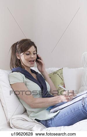 Relaxed woman on phone with documents View Large Photo Image Stock Photo - Relaxed woman on phone with documents. Fotosearch