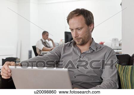 Relaxing and working on laptop View Large Photo Image Stock Image - Relaxing and working on laptop. Fotosearch