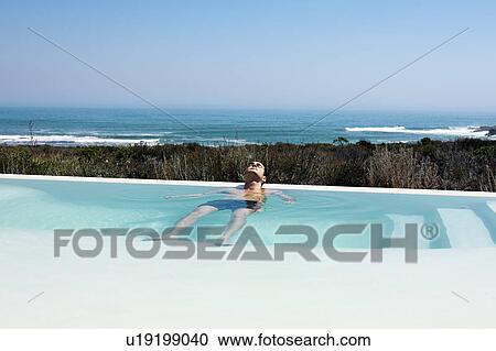 Stock Image - Relaxing in Infinity pool. Fotosearch