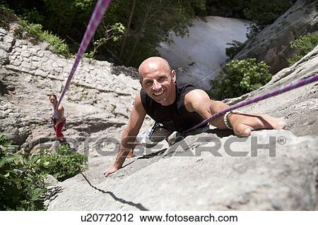 Stock Image - Rock climber climbing. Fotosearch