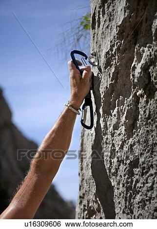 Rock climber securing himself View Large Photo Image Stock Photograph - Rock climber securing himself. Fotosearch