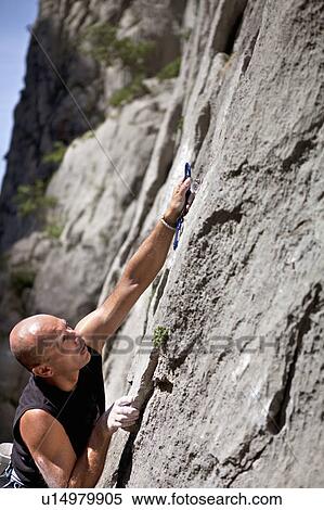 Rock climber securing himself View Large Photo Image Stock Photography - Rock climber securing himself. Fotosearch