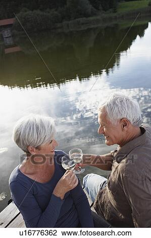Stock Image - Senior couple clinking glasses of wine. Fotosearch