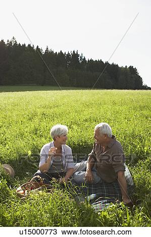 Senior couple having picnic in meadows View Large Photo Image Stock Image - Senior couple having picnic in meadows. Fotosearch