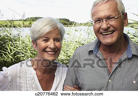 Senior couple outdoors smiling to camera View Large Photo Image Stock Image - Senior couple outdoors smiling to camera. Fotosearch