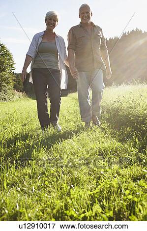 Senior couple walking in meadows View Large Photo Image Stock Photo - Senior couple walking in meadows. Fotosearch