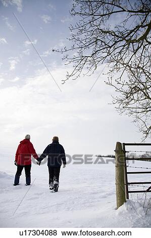 Senior couple walking in the snow View Large Photo Image Stock Photo - Senior couple walking in the snow. Fotosearch