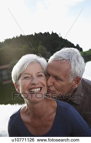 Stock Photograph - Senior man kissing woman. Fotosearch